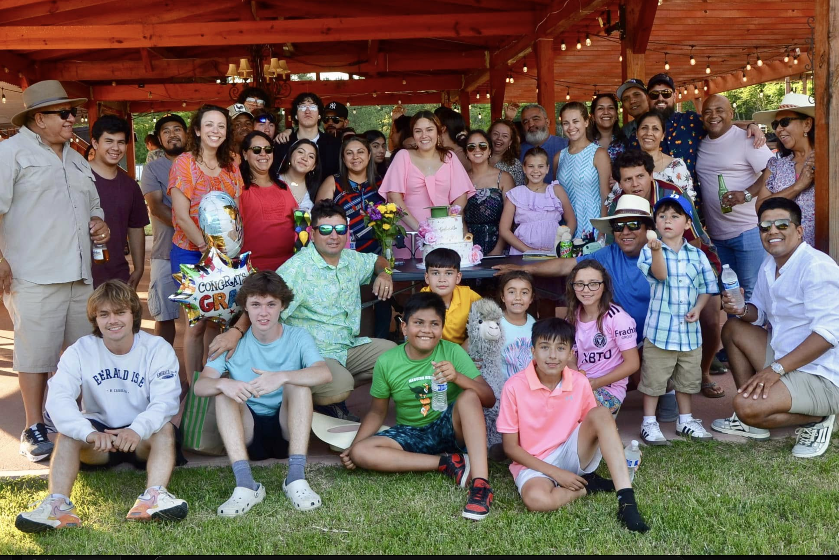 Outdoor graduation party at Camacho's Farms with guests celebrating around long tables with alpacas nearby